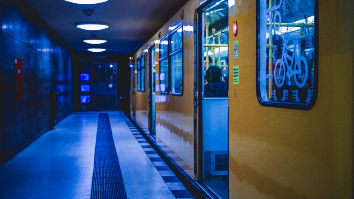 A yellow train at a Berlin subway station, illuminated at night, showcasing metro life.